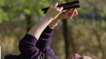 jovem mulher usando digital e livro em Relva dentro natureza video
