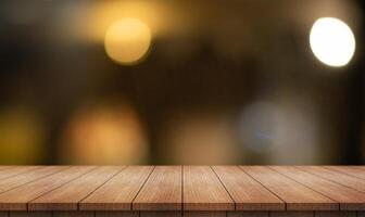 Empty wooden table top with lights bokeh on blur restaurant background. photo