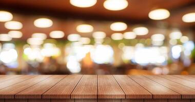 Empty wooden table top with lights bokeh on blur restaurant background. photo