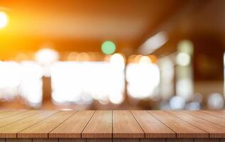 Empty wooden table top with lights bokeh on blur restaurant background. photo