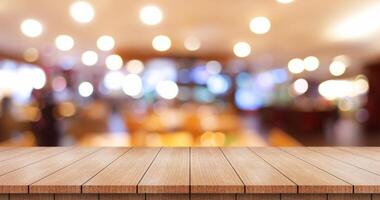 Empty wooden table top with lights bokeh on blur restaurant background. photo