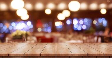 Empty wooden table top with lights bokeh on blur restaurant background. photo