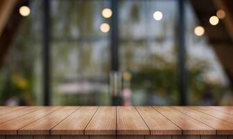 Empty wooden table top with lights bokeh on blur restaurant background. photo