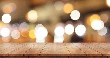 Empty wooden table top with lights bokeh on blur restaurant background. photo