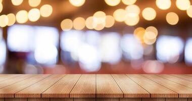 Empty wooden table top with lights bokeh on blur restaurant background. photo