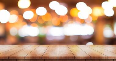 Empty wooden table top with lights bokeh on blur restaurant background. photo