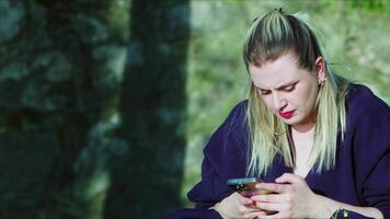 Young Woman is Using her Mobile Phone in Nature video