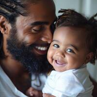 Smiling father holding his happy baby at home photo