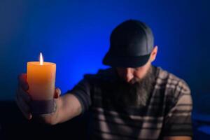 man holding a candle in hand photo