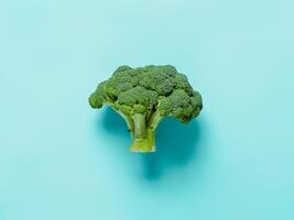 Broccoli on blue background, top view, copy space photo