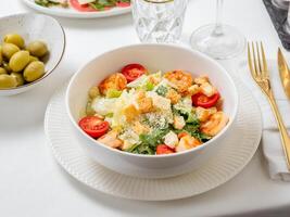 Caesar salad with shrimps on restaurant table photo