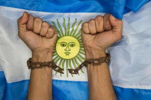 Fists that break the chains on the Argentine flag. Argentine revolution and independence concept photo