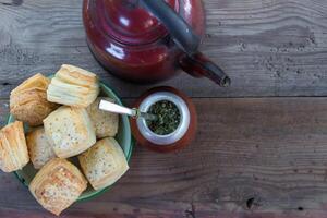 compañero y tetera con un plato de salado argentino galletas y yerba compañero infusión foto