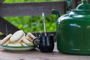 Mate and kettle with a plate of alfajores and yerba mate infusion in the Argentine countryside photo