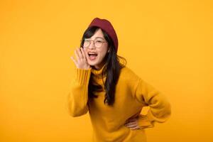 A fashionable lady, in a red beret and yellow sweater, makes a stylish announcement against a vibrant yellow background. photo