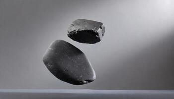 two rocks are floating in the air on a gray surface photo