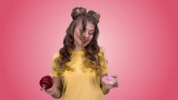 Beautiful young girl in a yellow T-shirt with a haircut makes a choice in favor of useful products and smiles. green screen video