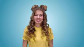 attractive young girl in a yellow vest with long hair shows a gesture of prohibition and smiling while looking at the camera. green screen video