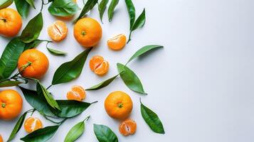 Fresh ripe tangerines and leaves on light white background. Flat lay, top view, copy space. photo