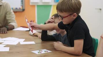 un africano americano profesor enseña un grupo de niños números utilizando flashcards.escuela para niños, enseñando adolescentes, ganancia conocimiento, aprender el idioma. video