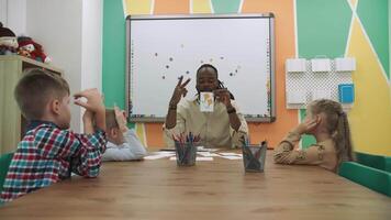 un africano americano profesor enseña un grupo de niños matemáticas.escuela para niños, enseñando adolescentes, ganancia conocimiento, aprender el idioma. video