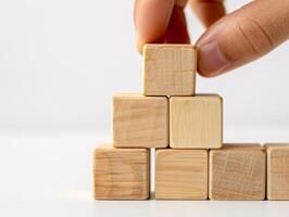 Hand putting and stacking blank wooden cubes on table with copy space can add text or icon photo