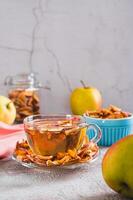 Delicious compote of aromatic dried apples in a cup on the table web banner vertical view photo