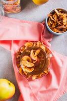 Sweet compote with dried apples in a mug on the table top and vertical view photo