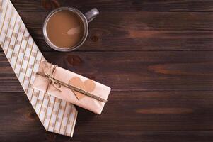 Father's day craft gift with heart on tie, coffee mug on wooden table top view photo