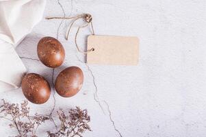 Homemade natural painted eggs for Easter, card and dried flowers top view photo
