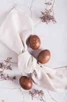 Homemade natural painted eggs for Easter, napkin and dry flowers top and vertical view photo