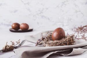 Happy Easter homemade naturally colored egg in a nest on a napkin on the table photo