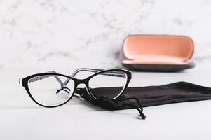 Eyeglasses on a soft case against the background of a hard case on the table photo