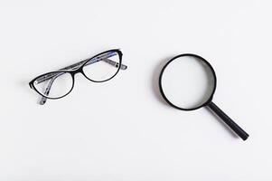 Choosing between vision glasses and a magnifying glass, top view photo