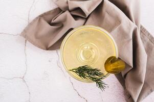 Close up of trendy martini cocktail with pickles and dill in a glass on the table top view photo