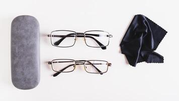 Whole glasses, broken glasses, hard case and cleaning cloth on table top view web banner photo