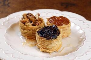 nest of Arabic sweets with grape jelly, apricot jam, chestnuts and honey photo