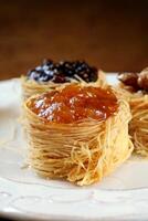 nest of Arabic sweets with grape jelly, apricot jam, chestnuts and honey photo