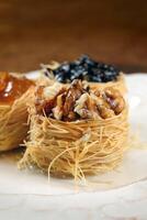 nest of Arabic sweets with grape jelly, apricot jam, chestnuts and honey photo