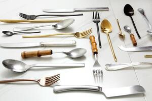 knives, cutlery, spoons and forks on a marble background photo