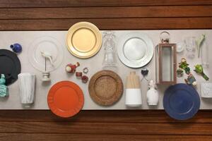 copper, crockery and silver plates, bowls and trays mounted on table seen from above photo