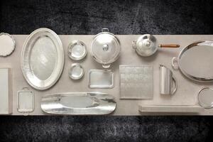 copper, crockery and silver plates, bowls and trays mounted on table seen from above photo