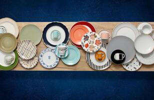 copper, crockery and silver plates, bowls and trays mounted on table seen from above photo