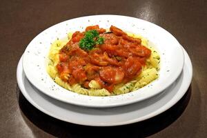 pasta con tomate salsa y salchicha en plato foto