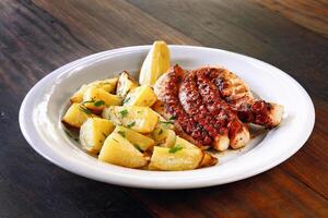 grilled octopus with rustic potatoes on plate photo