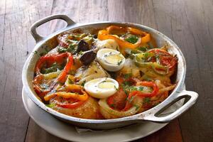 Wood-fired cod with eggs and peppers photo