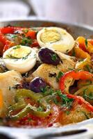 Wood-fired cod with eggs and peppers photo