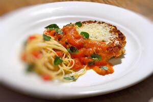 Filetto al Parmigiano with spaghetti with chopped tomatoes photo