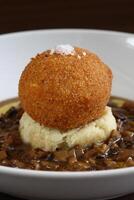 Egg Mollet breaded with mashed potatoes and dry mushroom sauce photo