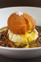 Egg Mollet breaded with mashed potatoes and dry mushroom sauce photo